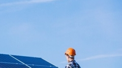 Man worker in the firld by the solar panels